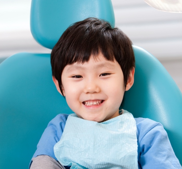 Child smiling during dental checkup and teeth cleaning with children's dentist