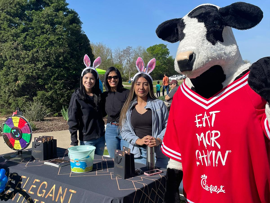 Person in cow costume taking selfie with three women
