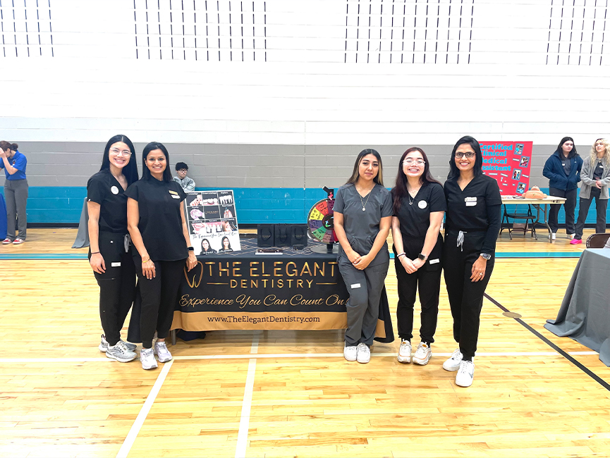 Five women standing in front of The Elegant Dentistry table