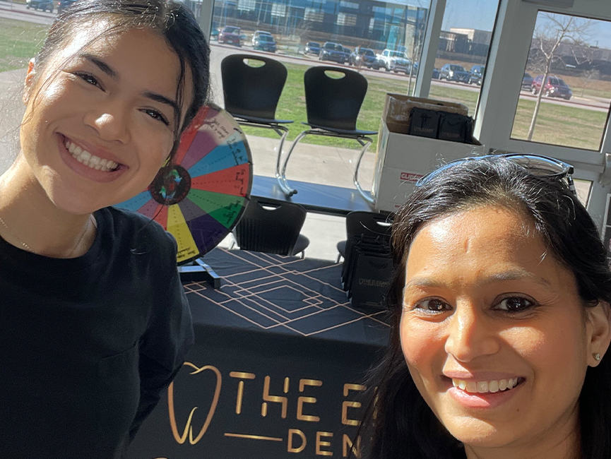 Close-up of women smiling in front of event table