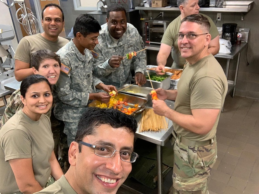 People in army clothes around some food