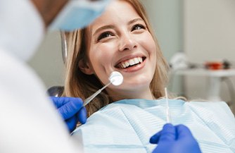 Dentist examining smiling patient's teeth