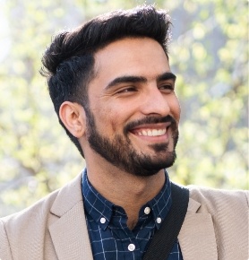 Man in plaid shirt smiling outdoors