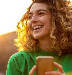 Young woman holding cell phone outdoors