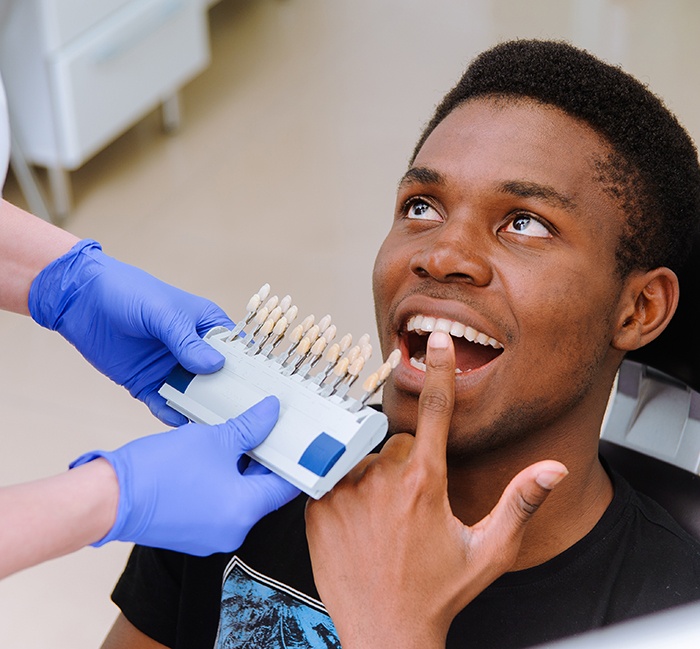 Male patient touching his tooth during a dental visit