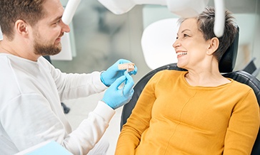 Dentist discussing treatment with a female patient wearing yellow