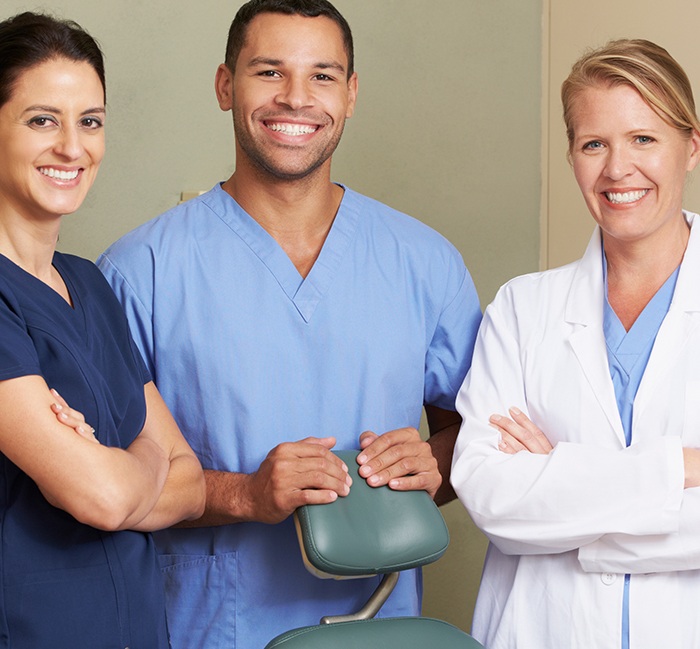 Dentist and team members smiling