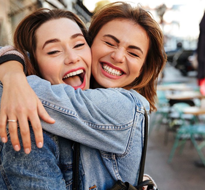 female friends laughing and hugging 